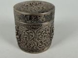 a small silver box with a floral design on the lid