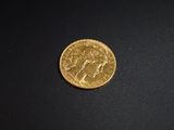 gros plan d'une pièce d'or sur une surface noire