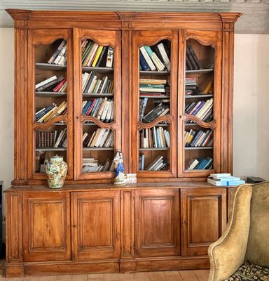 une grande bibliothèque en bois sur laquelle sont posés de nombreux livres
