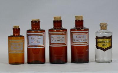 several bottles of medicine are lined up on a white surface
