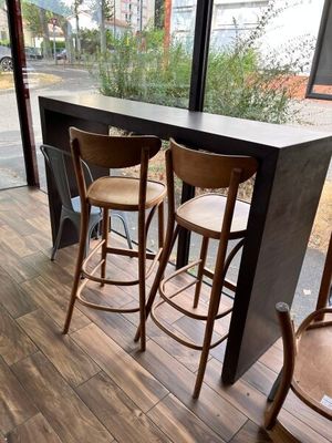 three wooden stools sitting in front of a window