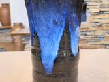 un vase bleu et noir posé sur une table