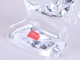 a clear glass horse figurine with a red tag on it