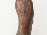 bronze statue of a man with a hat on a wooden table