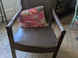 une chaise marron avec un coussin dessus, dans une pièce