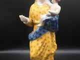 une figurine représentant une femme tenant un bébé dans ses bras