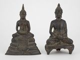 deux statues de Bouddha en bronze assises sur une petite table