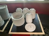 de nombreuses assiettes et tasses posées sur un plateau posé sur la table