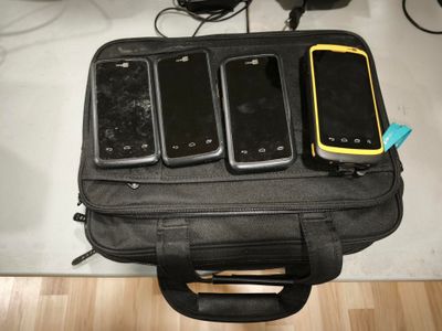 several cell phones are sitting in a black bag on a table