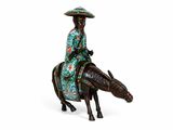 figurine of a woman riding a horse with a hat on her head