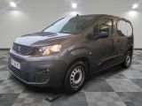 la camionnette grise est garée sur le sol en damier d'un garage