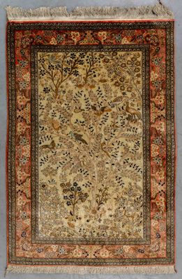 an antique persian rug with a floral design on a beige ground