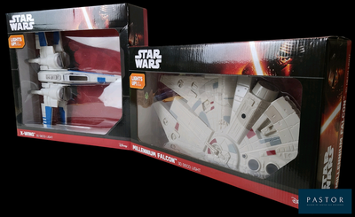 Deux boîtes de jouets Star Wars sont posées côte à côte sur un fond noir