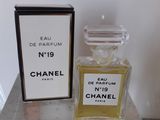 Flacon et coffret du parfum Chanel n° 19 posés sur une table en marbre