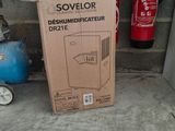 a cardboard box sitting on the ground next to a fire extinguisor