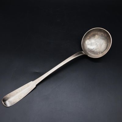 a silver spoon with a spoon handle on a black surface
