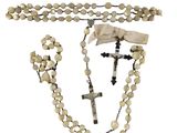 a close up of a rosary and a cross on a white background