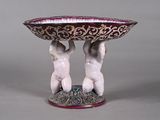 two figurines holding a bowl on top of each other