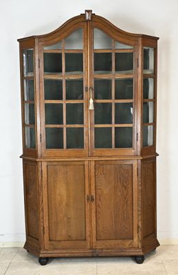 une grande armoire en bois surmontée de portes vitrées