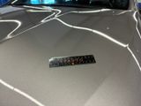 a close up of a silver car with a sticker on it