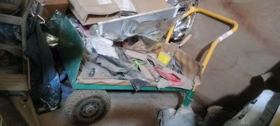 a cart full of items sitting on the floor of a garage