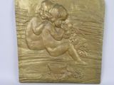 a close up of a gold plaque with a child on it