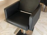 une chaise noire placée devant un miroir dans un salon