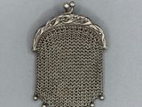 un petit porte-monnaie en argent muni d'une chaîne