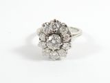 un gros plan d'une bague sertie de diamants en grappe sur fond blanc