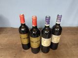 several bottles of wine are lined up on a wooden table