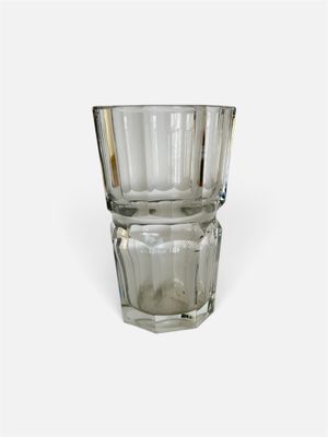 un verre posé sur une surface blanche