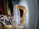a room with a bed, a chair, and a closet with clothes
