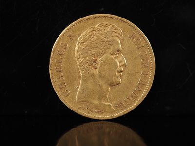 gros plan d'une pièce d'or sur une surface noire