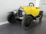 une petite voiture jaune posée par terre dans une pièce