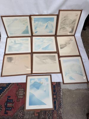many pictures of a mountain are displayed on a table