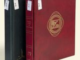 two red and black binders with a gold seal on them