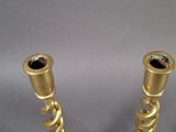 pair of gold colored candlesticks on a grey background