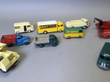 Plusieurs petites voitures et camions sont alignés sur une table