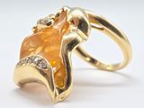 une image représentant une bague en or sertie d'une pierre orange et de diamants