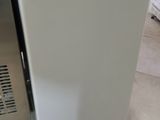 a small white refrigerator sitting in a kitchen next to a refrigerator freezer