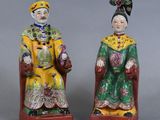pair of chinese figurines of a man and a woman sitting on a chair