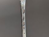 a silver spoon with a small bird on it