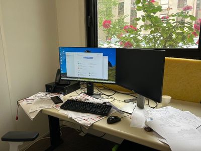 un bureau sur lequel sont posés deux écrans d'ordinateur et un clavier