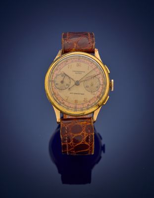 a close up of a gold wrist watch on a blue surface