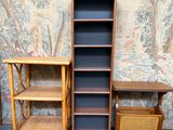 two bookshelves and a table in front of a wallpapered wall