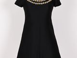 une robe noire avec des perles et des perles sur le cou
