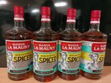 quatre bouteilles d'alcool sont alignées sur un plan de travail