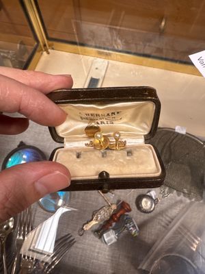 a person holding a ring in a box with a knife and fork
