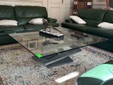 un homme debout dans un salon, à côté d'un canapé