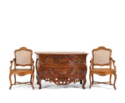 two chairs and a chest of drawers with carvings on the top